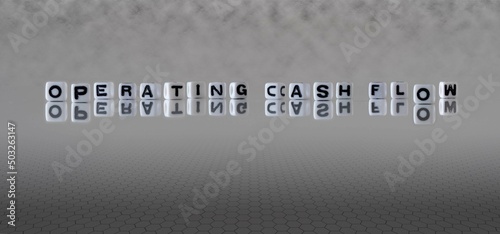 operating cash flow word or concept represented by black and white letter cubes on a grey horizon background stretching to infinity