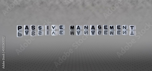 passive management word or concept represented by black and white letter cubes on a grey horizon background stretching to infinity