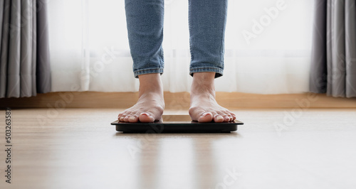 Woman's feet weighing on scales. weight loss, self care and body Concept.