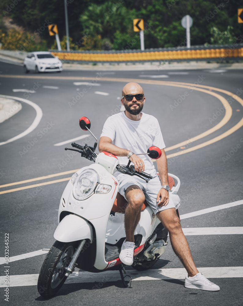 Stylish young man with his motorbike on the road Stylish young man with his motorbike on the road