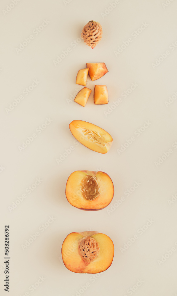 Layout made of peach peaces and halves on the nude background. Fruty composition flat lay.