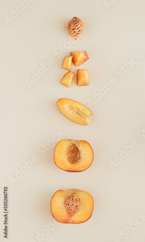 Layout made of peach peaces and halves on the nude background. Fruty composition flat lay.
