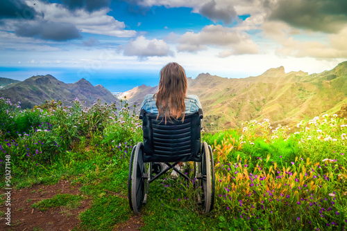 Leinwand Poster Disabled handicapped woman in wheelchair on mountain hill enjoying view