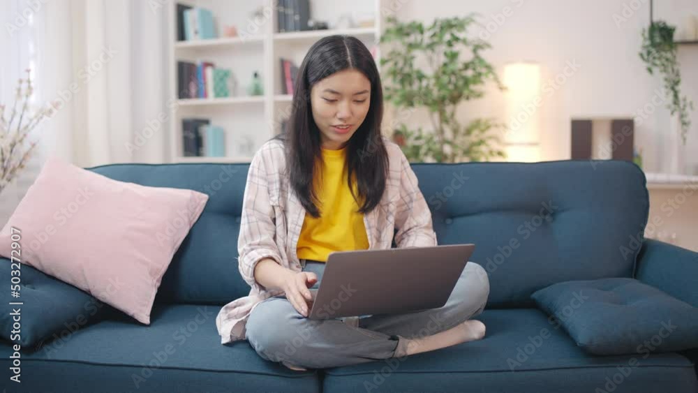Young Asian woman having online video call on laptop, talking with a friend Young Asian woman having online video call on laptop, talking with a friend