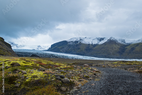 Iceland autumn tundra landscape near Haoldukvisl glacier, Iceland. Glacier tongue slides from the Vatnajokull icecap or Vatna Glacier near subglacial Esjufjoll volcano. People unrecognizable.