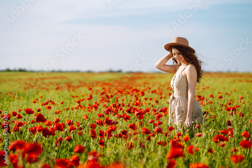 Beautiful woman in the blooming poppy field. Nature, vacation, relax and lifestyle. Summer landscape.