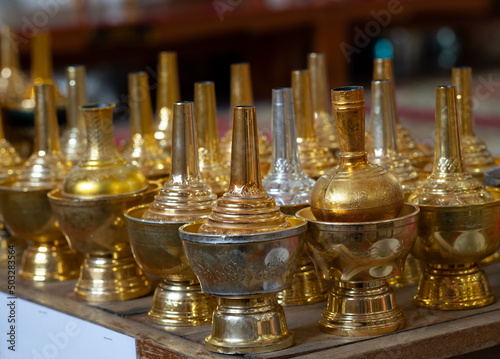 Golden jar for Thai traditional ceremony, pouring water after make merit for Buddhism religious ceremony. Spot focus.