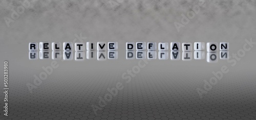 relative deflation word or concept represented by black and white letter cubes on a grey horizon background stretching to infinity