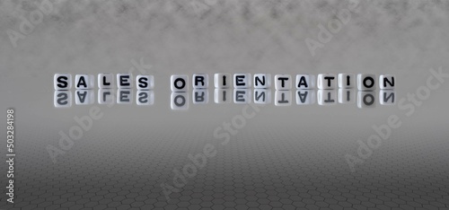 sales orientation word or concept represented by black and white letter cubes on a grey horizon background stretching to infinity