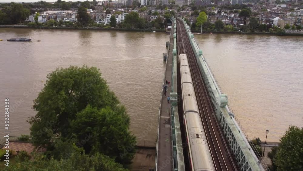 A drone view of a London Underground train on the Fulham Railway Bridge.