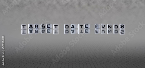 target date funds word or concept represented by black and white letter cubes on a grey horizon background stretching to infinity