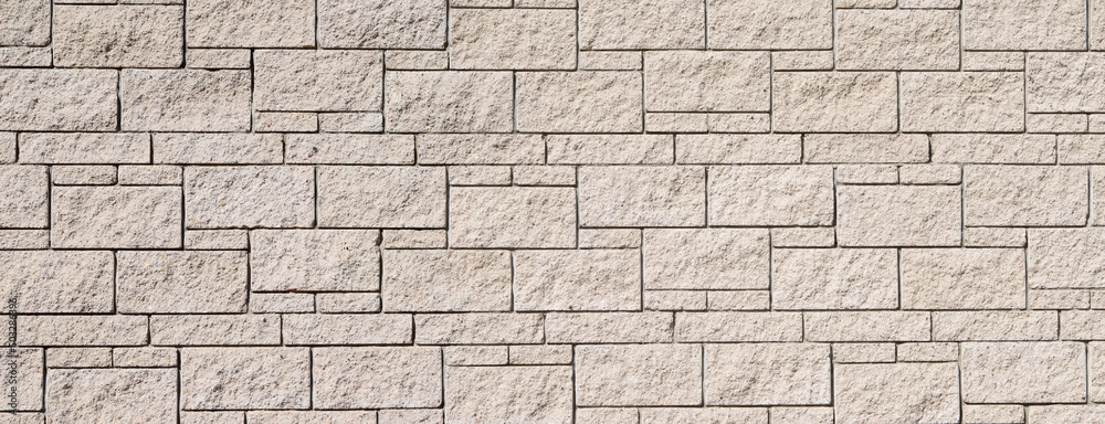 The texture of the surface of a white and yellow brick concrete wall, cement pattern with cracks on the background with space to copy, panoramic view