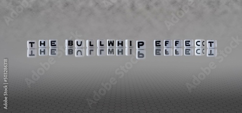 the bullwhip effect word or concept represented by black and white letter cubes on a grey horizon background stretching to infinity photo