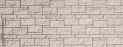 The texture of the surface of a white and yellow brick concrete wall  cement pattern with cracks on the background with space to copy  panoramic view