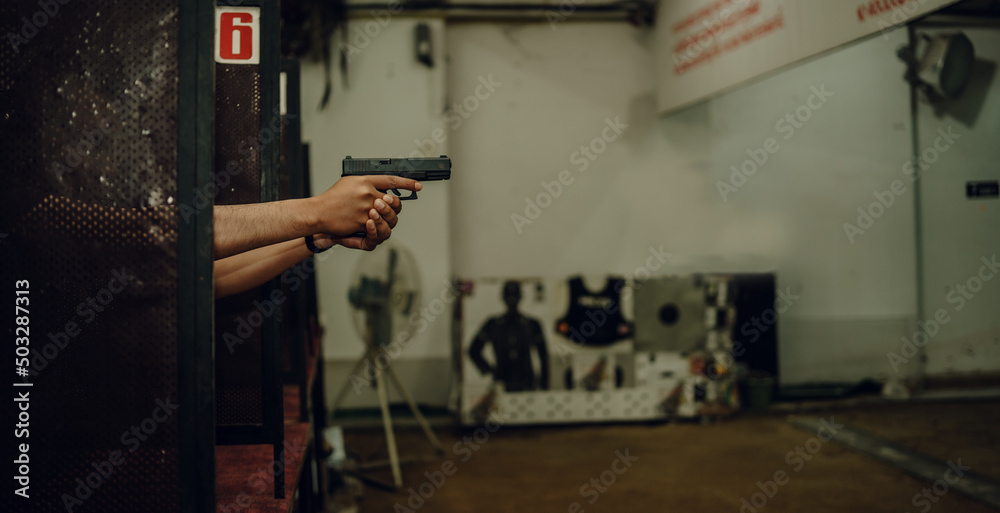 Professionals practice shooting a 9mm pistol inside a shooting range. Professionals practice shooting a 9mm pistol inside a shooting range.