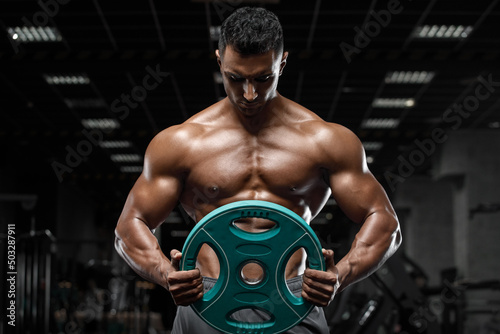Muscular man working out in gym, strong arab male, naked torso abs