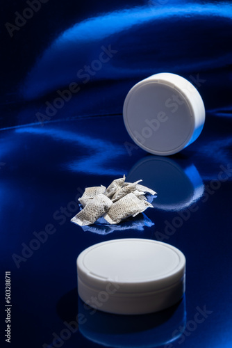 Closeup of white Swedish snus pouches against a blue background. Smokeless tobacco. photo