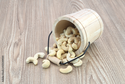 Roasted cashew nut in bucket on wooden texture background.