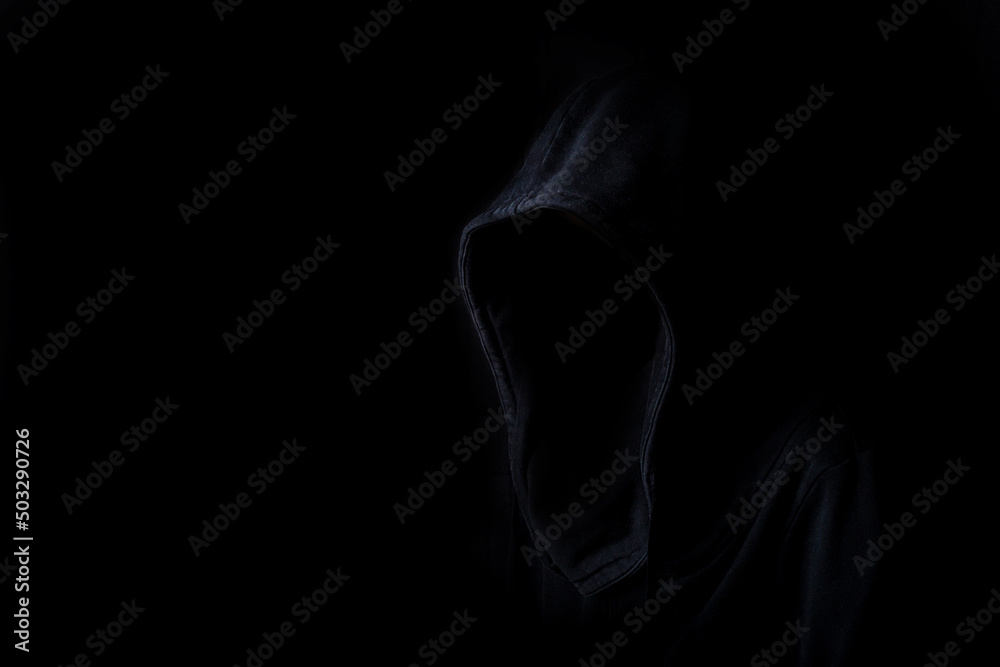 Faces are not visible in black robes in the dark on a black background Faces are not visible in black robes in the dark on a black background