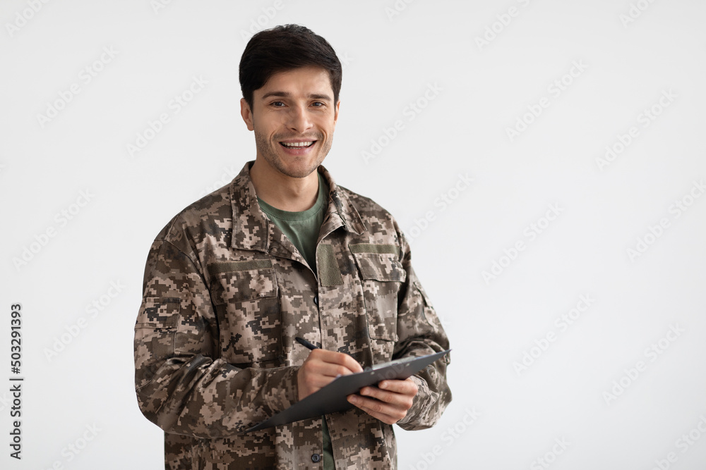 Smiling man in camouflage uniform holding folder Smiling man in camouflage uniform holding folder