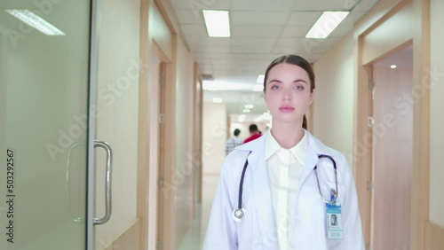 Portrait of Confident, successful professional woman doctor in uniform white lab coat, stethoscope. Female physician while work walking along corridor, examination room in hospital medical office.