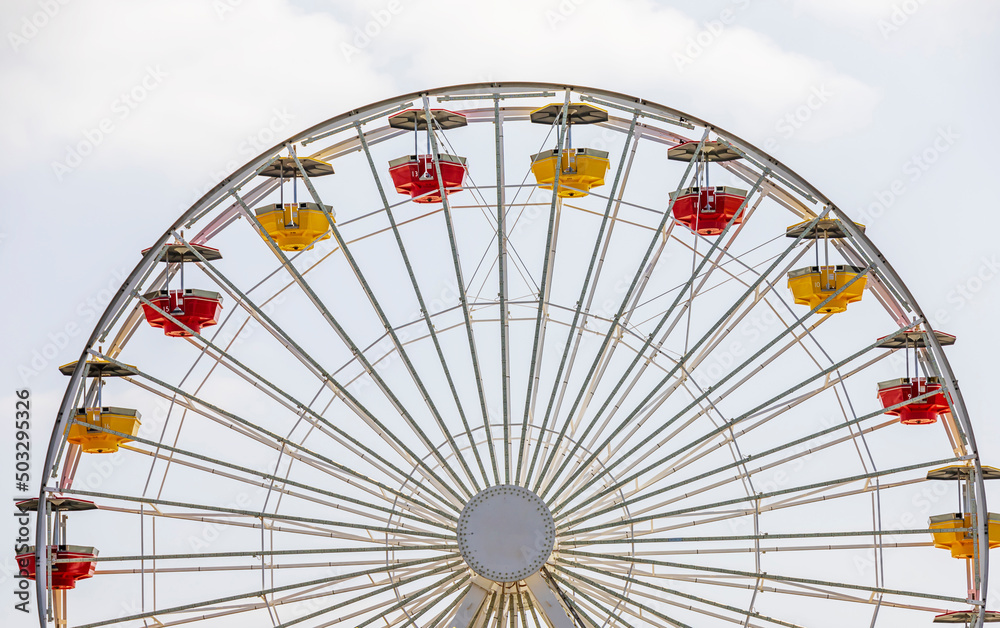 Yellow and red carts on a large white Ferris wheel Yellow and red carts on a large white Ferris wheel