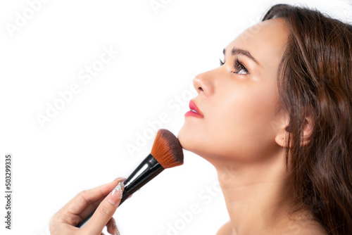 Beautiful young Asia woman apply cosmetic powder on her face using cosmetic brush isolated on white background. Close up facial make up. Beauty concept. Skin and natural make up.