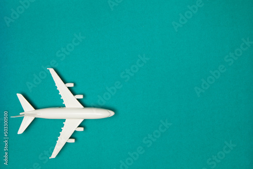 Airplane model. White plane on green background. Travel vacation concept. Summer background. Flat lay, top view, copy space. © hamara