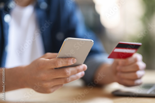 Online Payments. Closeup Shot Of Man Using Smartphone And Bank Card © Prostock-studio