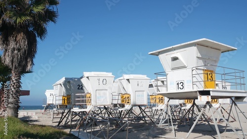 Lifeguard stand and palm tree, life guard tower for surfing on California beach. Summer pacific ocean in USA aesthetic. Iconic rescue baywatch station, coast lifesavers wachtower hut or house by sea.
