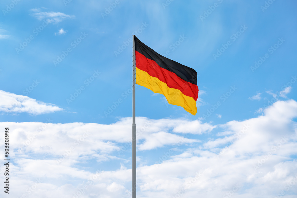 Flag of Germany in front of blue sky and clouds Flag of Germany in front of blue sky and clouds