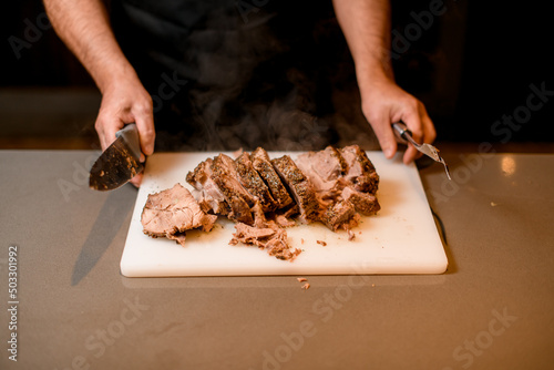 Selective focus on tasty hot slices of fried meat on white cutting board