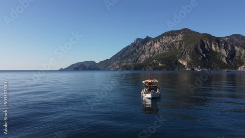 The old man and the sea. Fisherman and a small fishing boat against the backdrop of a beautiful calm sea and mountains. High quality 4k footage