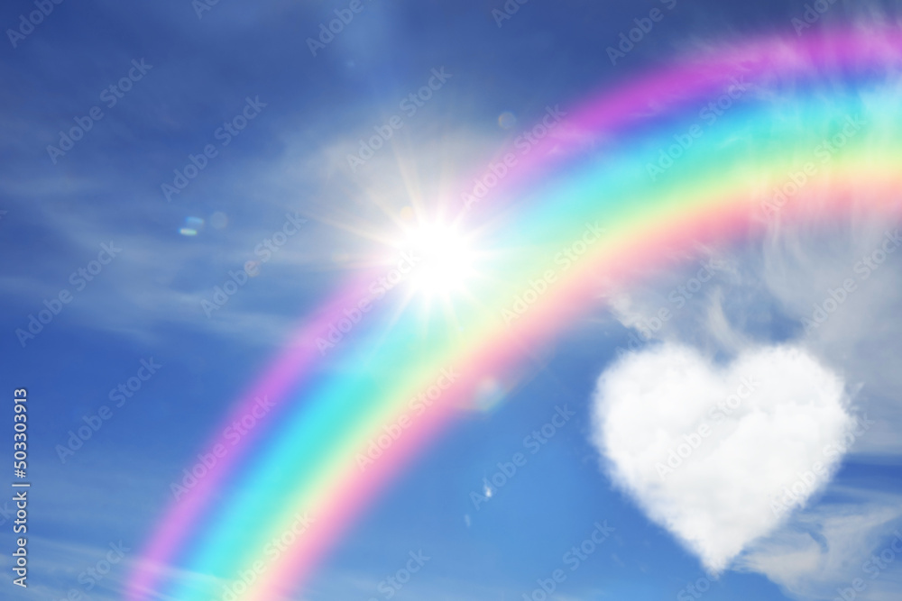 Beautiful view of heart shaped cloud, rainbow and sun in blue sky