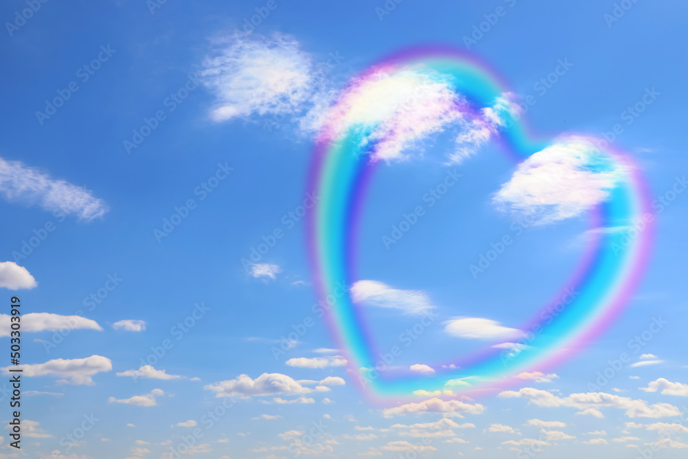 Beautiful view of heart shaped rainbow and white clouds in blue sky on sunny day Beautiful view of heart shaped rainbow and white clouds in blue sky on sunny day
