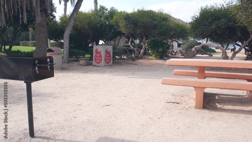 Picnic area in public park, La Jolla Cove, California coast, USA. Recreation place for barbecue. Bbq hot coals only cement dumpster. Table and bench for barbeque, grill and rest alfresco. Fire safety. Picnic area in public park, La Jolla Cove, California coast, USA. Recreation place for barbecue. Bbq hot coals only cement dumpster. Table and bench for barbeque, grill and rest alfresco. Fire safety.