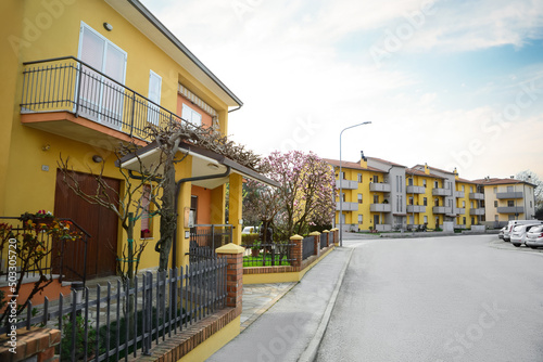 Fototapeta Naklejka Na Ścianę i Meble -  Suburban street with beautiful apartment buildings and blossoming trees on sunny spring day
