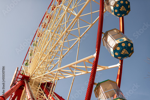 Round ferris wheel spins fast at colorful day photo