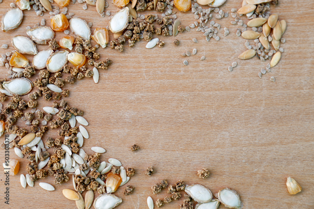 Fototapeta premium Different vegetable seeds on wooden table, flat lay. Space for text