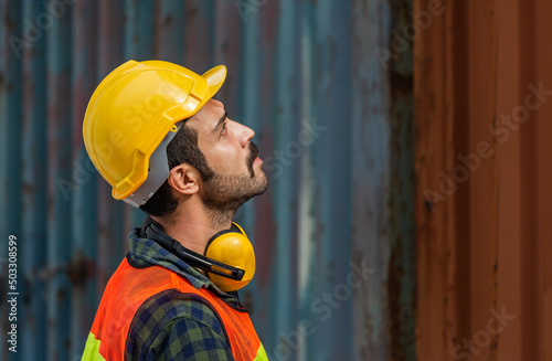 Industrial engineer in hard hat over blurred containers box background, Dock worker man at containers cargo, Logistic and transportation concepts
