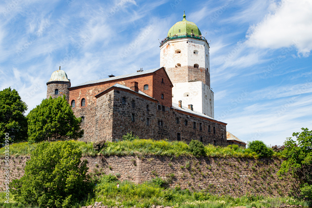 Old Vyborg Castle with the flag of Russia on the tower on clear summer day