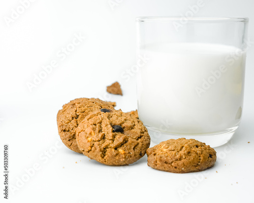 Chocolate chip cookies with glass of milk on wood plate and isolated white background. 