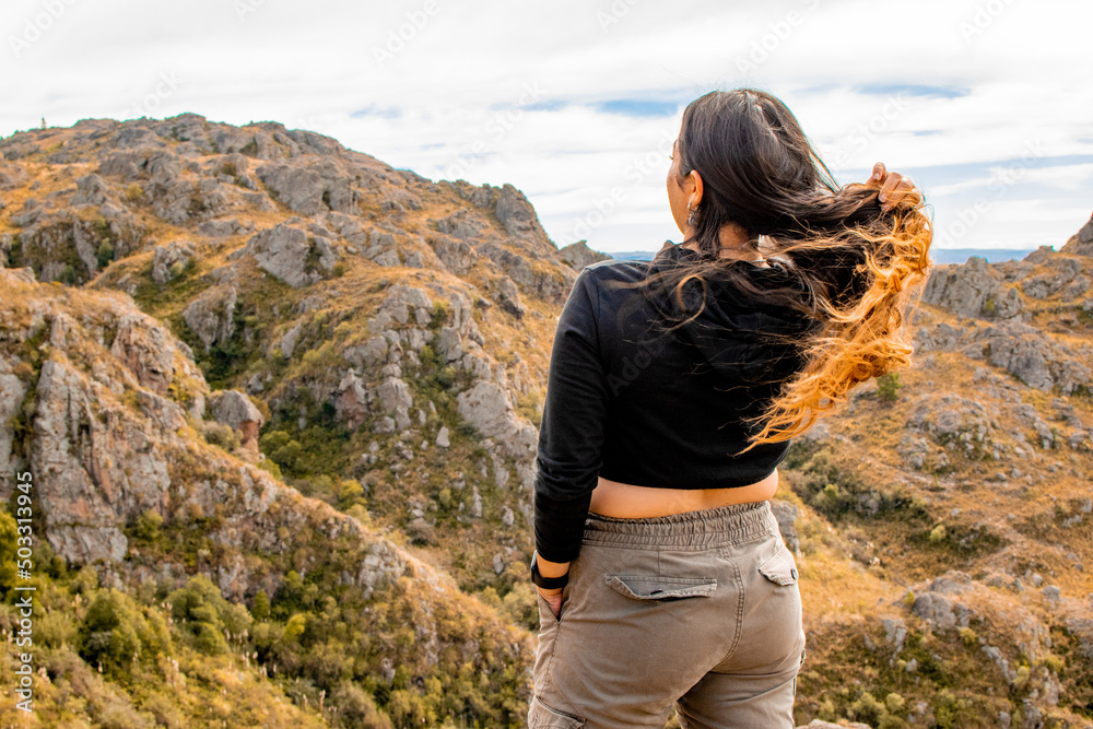 Portrait of latin woman having fun during trekking day in mountain forest posing on a rock- Back focus Portrait of latin woman having fun during trekking day in mountain forest posing on a rock- Back focus