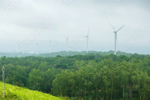 windmill power plant in forest with heavy mist, Korat