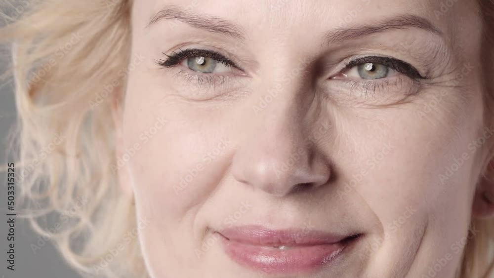 An old European white woman doing make up and drawing eyeliner An old European white woman doing make up and drawing eyeliner