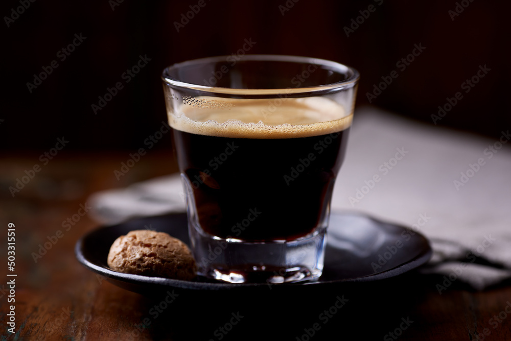 Coffee in glass cup on dark wooden background. Close up. Coffee in glass cup on dark wooden background. Close up.