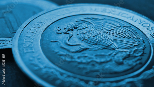 Coin of 5 Mexican pesos close up. Peso of Mexico. Reverse of coin with coat of arms of country. Eagle and snake. Blue tinted money wallpaper. News about economy or business. Loan and credit. Macro