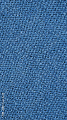 Blue woven surface closeup. Linen textile texture. Graceful color fabric background. Vertical textured braided backdrop. Textured mobile phone wallpaper. Macro