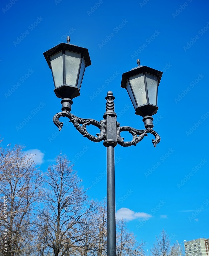 Retro lanterns on a black cast iron pole