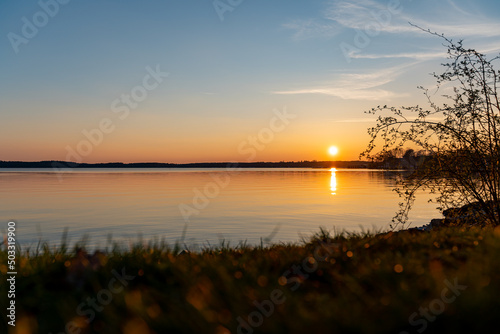 Lake M  ritz when the sun is going down. Natural landscape during spring season. Beautiful sunset scenery with reflections in the water. Orange sunlight over the horizon.
